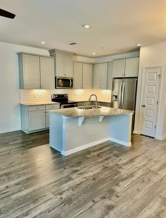 a kitchen with stainless steel appliances granite countertop a sink and a refrigerator