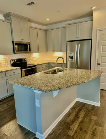 a kitchen with stainless steel appliances granite countertop a sink a stove a refrigerator a microwave and cabinets