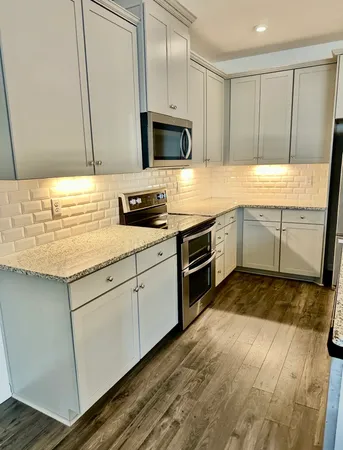 a kitchen with granite countertop cabinets stainless steel appliances and a sink