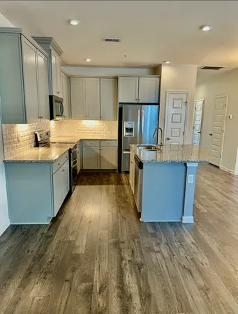 a large kitchen with lots of counter top space and stainless steel appliances