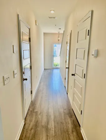 a view of a hallway with wooden floor and staircase