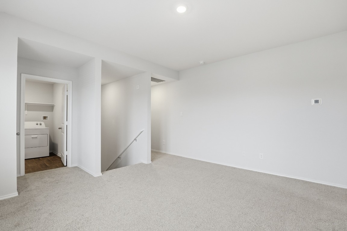 427 Sickle Loop Kyle, TX 78640 - Photo 11 of 39 Carpeted empty room featuring washer / clothes dryer and baseboards