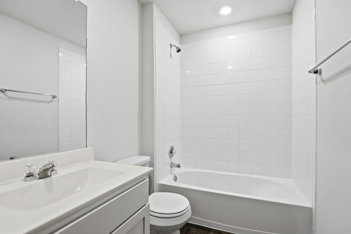427 Sickle Loop Kyle, TX 78640 - Photo 16 of 39 Full bath with vanity, washtub / shower combination, dark wood-style floors, and recessed lighting