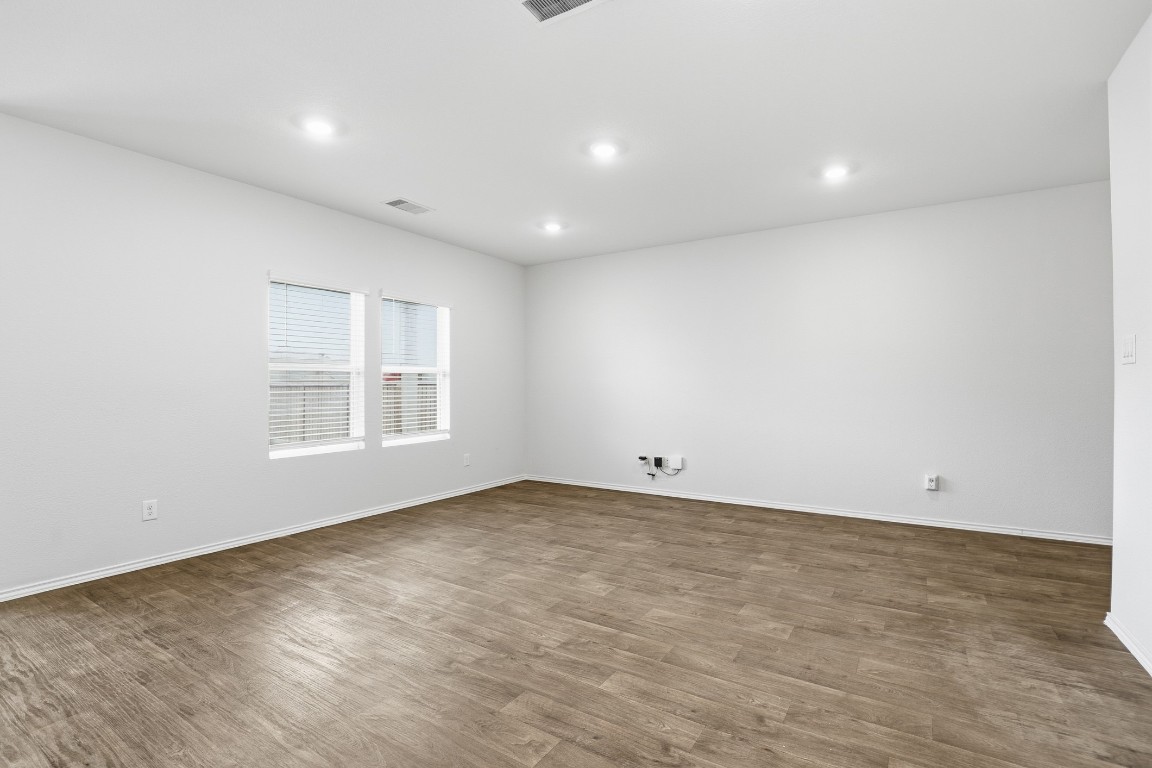 427 Sickle Loop Kyle, TX 78640 - Photo 31 of 39 Empty room featuring wood finished floors and recessed lighting