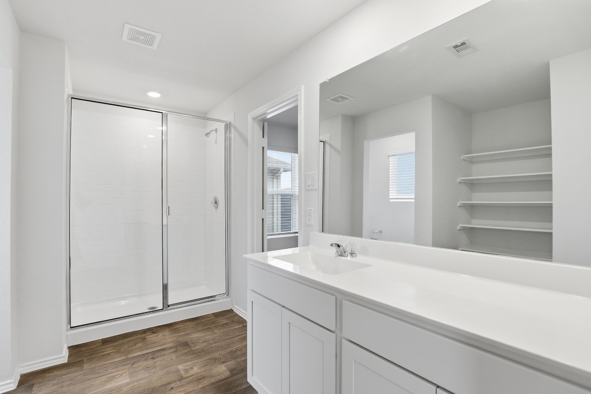 427 Sickle Loop Kyle, TX 78640 - Photo 5 of 39 Full bathroom featuring a stall shower, vanity, and dark wood-style floors