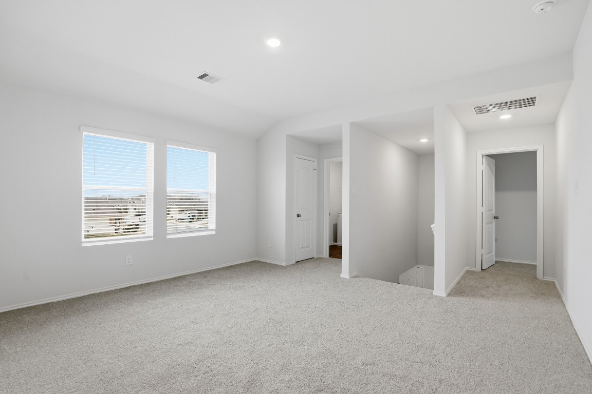 427 Sickle Loop Kyle, TX 78640 - Photo 8 of 39 Unfurnished bedroom featuring light colored carpet and recessed lighting