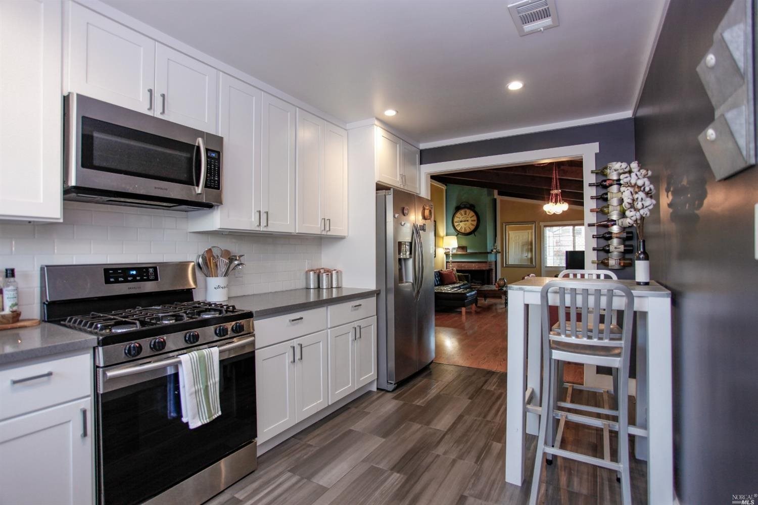 a kitchen with stainless steel appliances kitchen island granite countertop a stove and a microwave