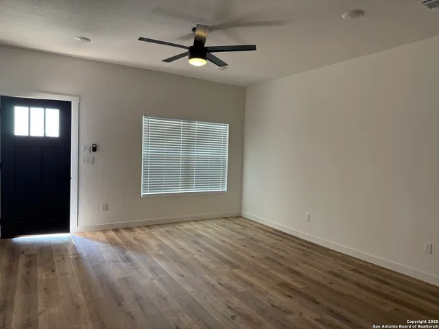 wooden floor in an empty room with a window