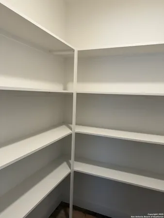 a view of walk in closet with empty racks