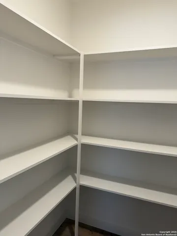 a view of walk in closet with empty racks