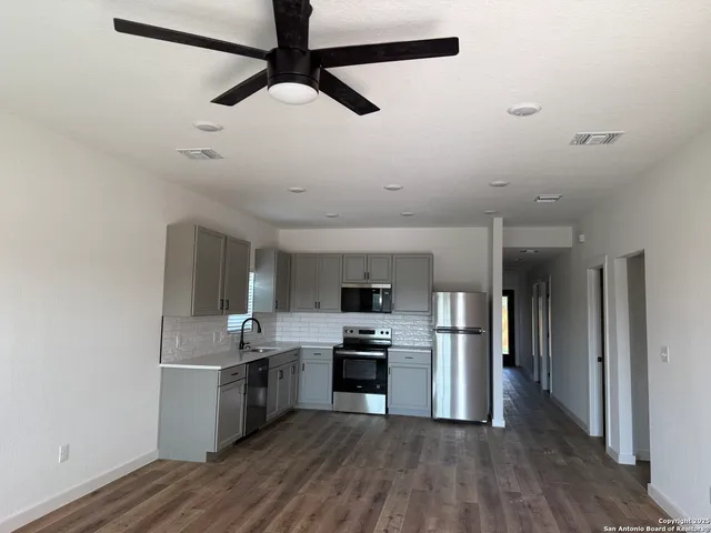 a kitchen with stainless steel appliances granite countertop a refrigerator and a stove top oven