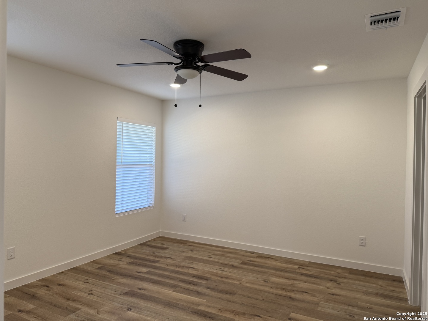 2105 Vista Rosa Three Rivers, TX 78071 - Photo 10 of 14 an empty room with wooden floor fan and windows
