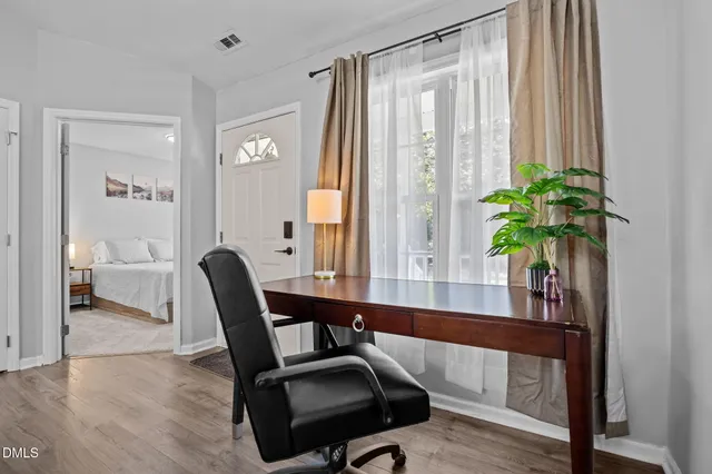 a view of a workspace with furniture and a window