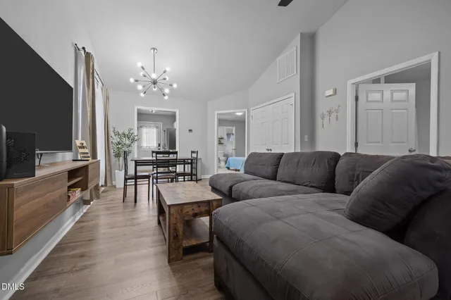 a living room with furniture a ceiling fan and a flat screen tv