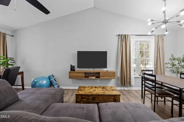 a living room with furniture a potted plant and a chandelier