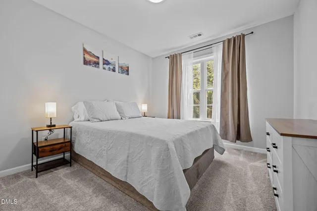 a spacious bedroom with a bed and a window