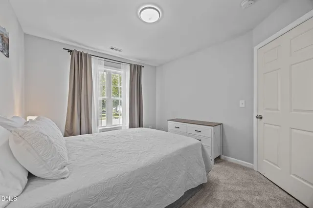 a spacious bedroom with a bed and a window