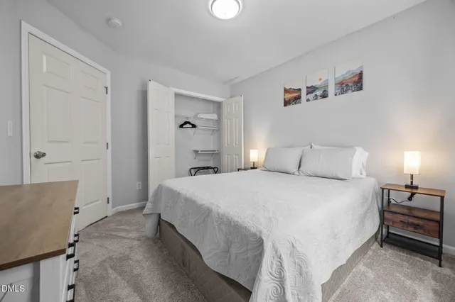 a spacious bedroom with a bed and lamp