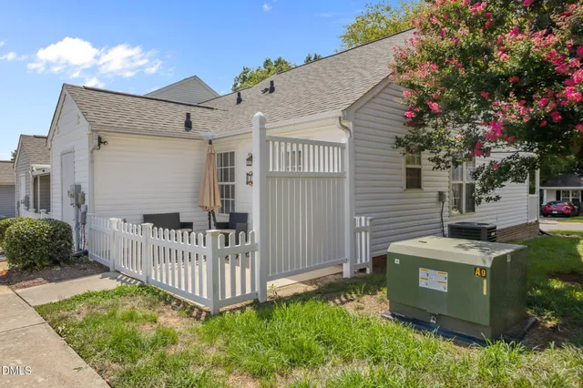 a view of a house with a small yard and wooden fence