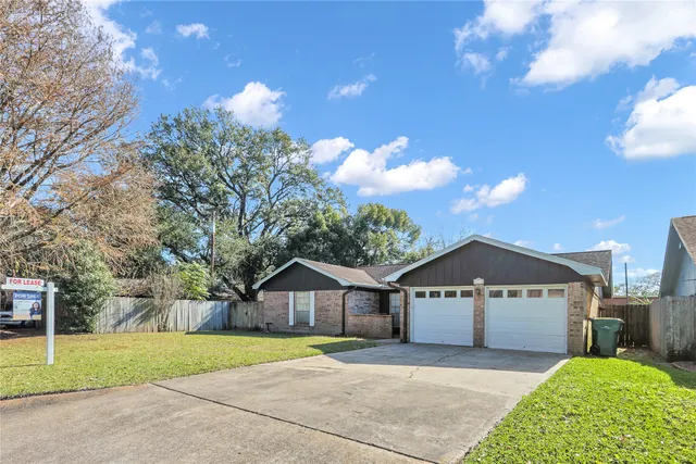 a view of a house with a yard and large tree