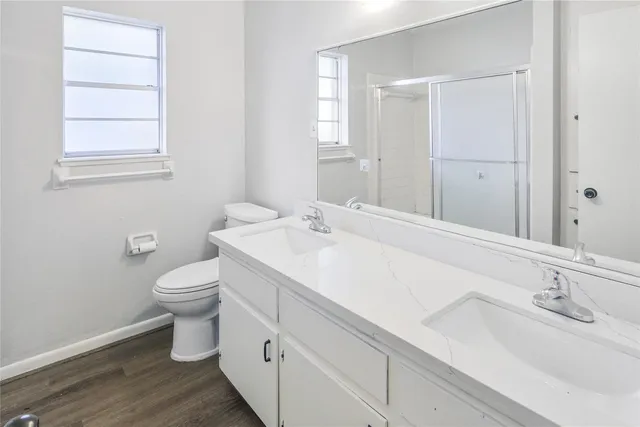 a bathroom with a granite countertop sink mirror and a toilet