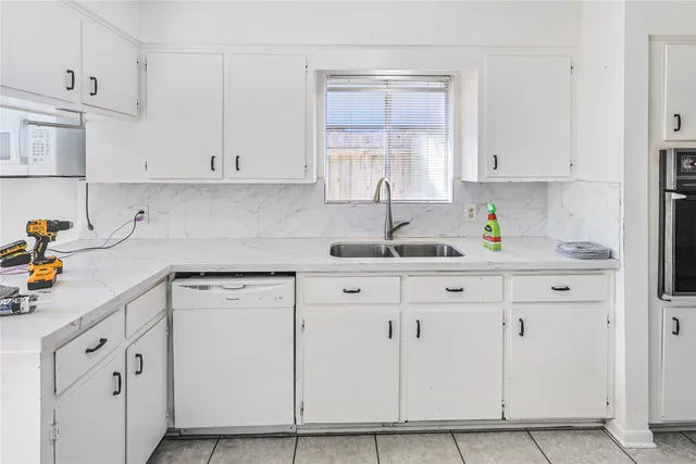 a kitchen with white cabinets and white appliances
