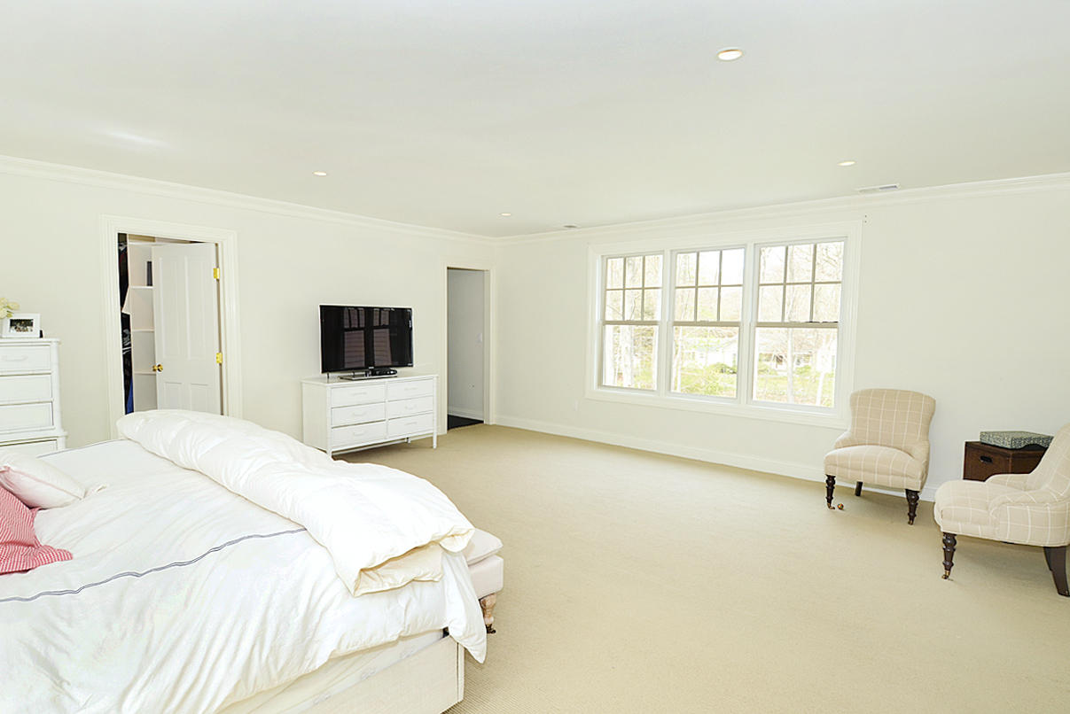 277 Country Club Road New Canaan, CT 06840 - Photo 15 of 29 a spacious bedroom with a bed and a chair