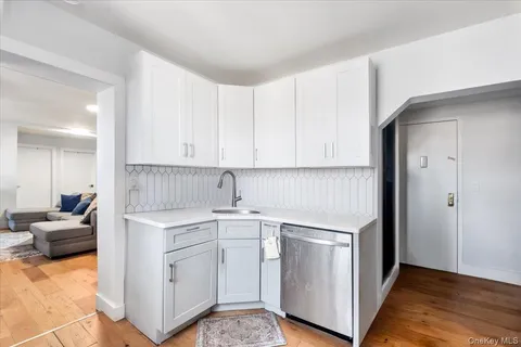 a kitchen with white cabinets and sink
