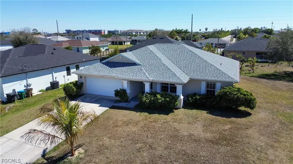 a view of a house with a yard and potted plants
