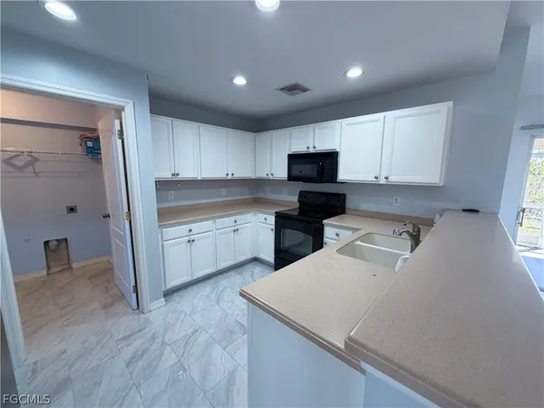 a kitchen with a sink a stove and cabinets