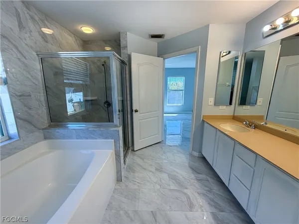 a large spacious bathroom with a tub shower and sink