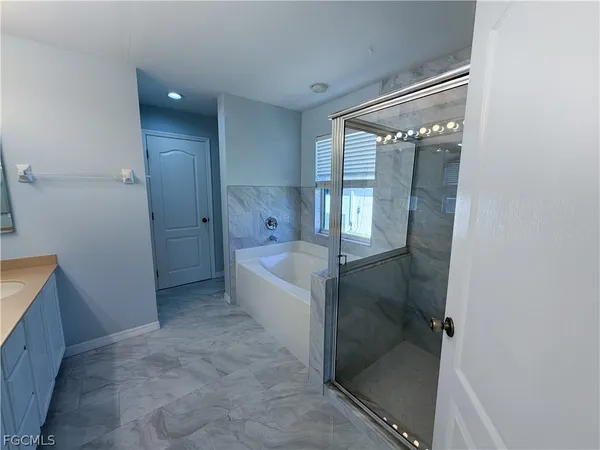 a spacious bathroom with a bathtub and shower