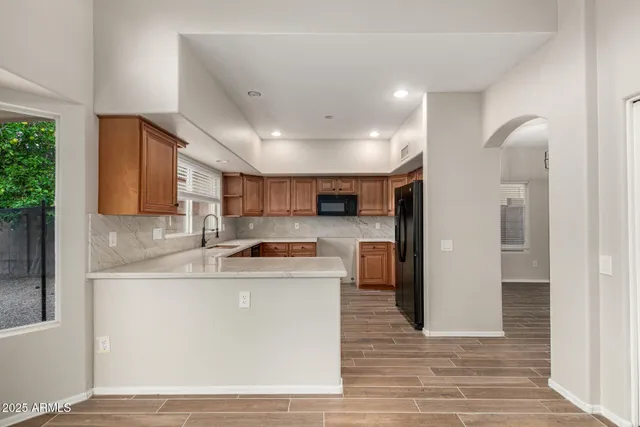 a kitchen with stainless steel appliances granite countertop a sink a stove a refrigerator and a cabinets