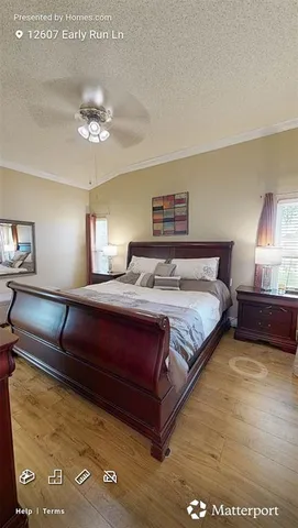 a spacious bedroom with a bed a couch and chandelier