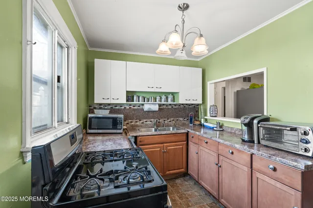 a kitchen with kitchen island granite countertop a sink stove and cabinets