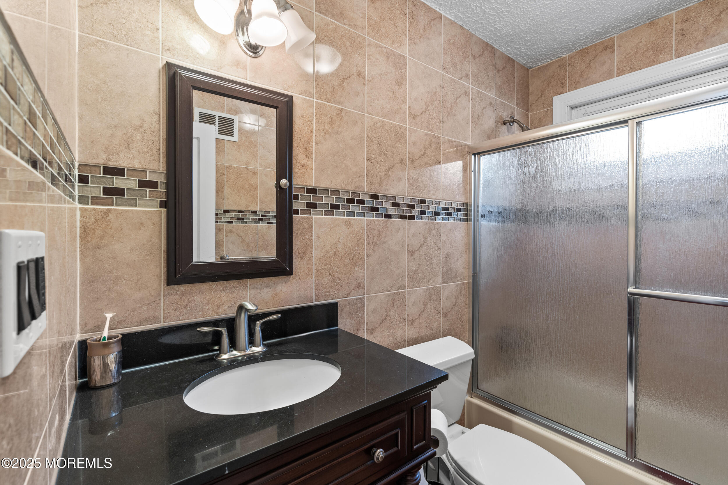 185 Pinecrest Road Oakhurst, NJ 07755 - Photo 12 of 23 a bathroom with a granite countertop sink toilet a mirror and shower