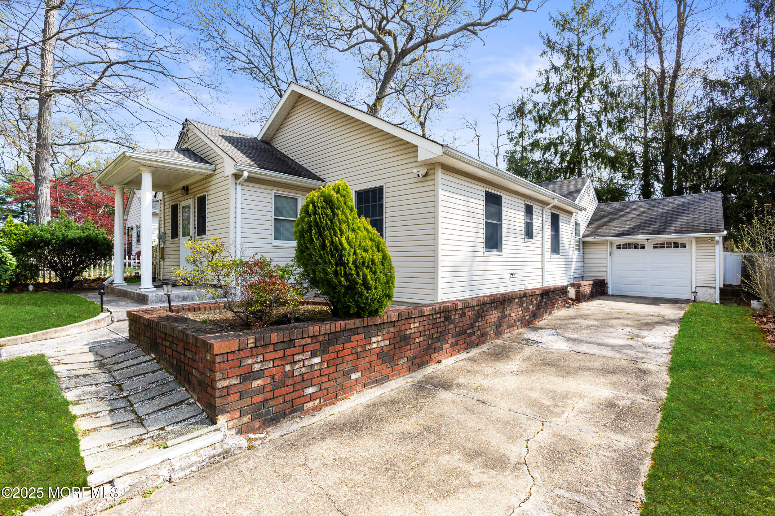 185 Pinecrest Road Oakhurst, NJ 07755 - Photo 15 of 23 a view of a white house next to a yard with potted plants and large trees