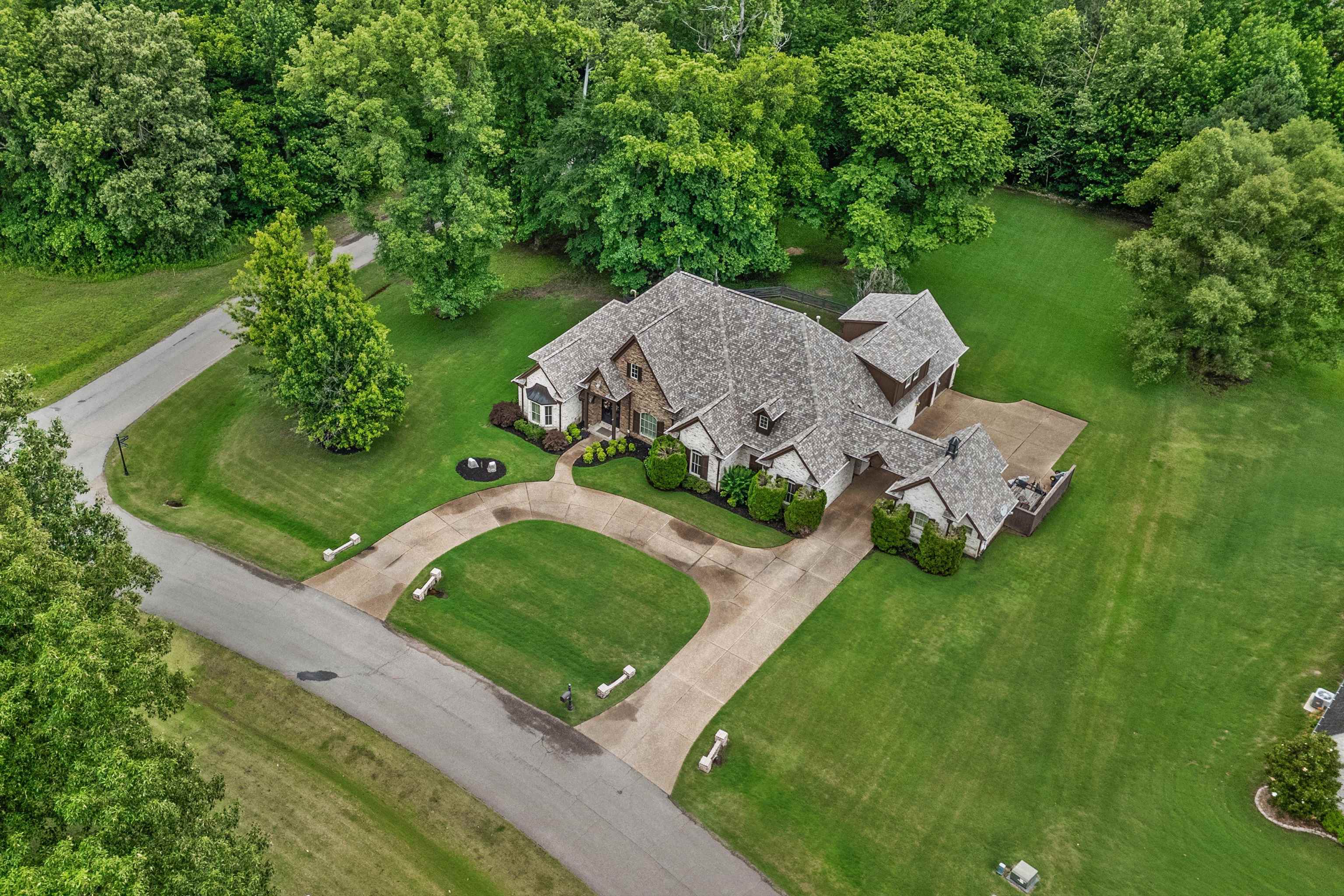 150 Ridgecrest Drive Arlington, TN 38002 - Photo 37 of 40 Expansive property featuring a stone and siding exterior, a multi-gabled roofline, and a circular driveway