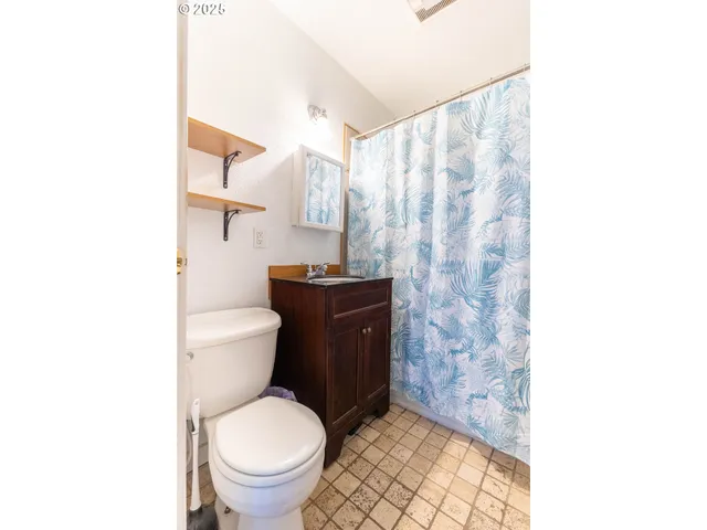 a bathroom with a toilet and a shower curtain