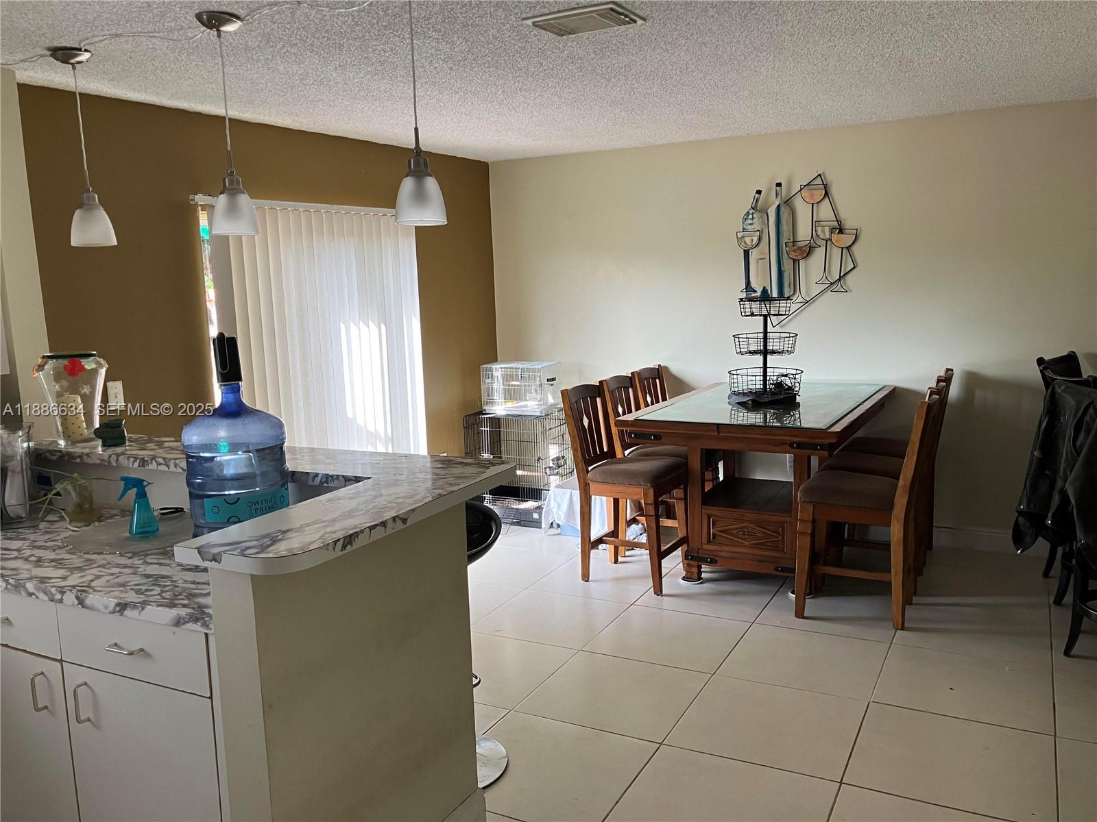 6970 Northwest 174th Terrace, Unit 404 Hialeah, FL 33015 - Photo 4 of 20 a kitchen with a table and chairs in it