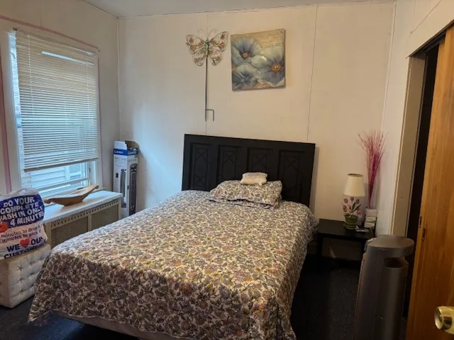 a bedroom with a bed and a flat tv screen on dresser