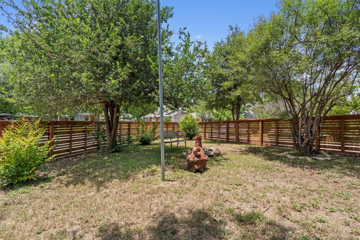 8615 Croydon Loop Austin, TX 78748 - Photo 26 of 28 a view of backyard with wooden fence and a large tree