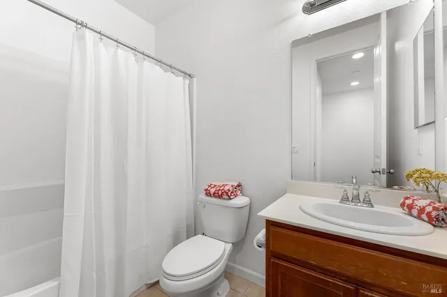 a bathroom with a sink a toilet and shower curtain