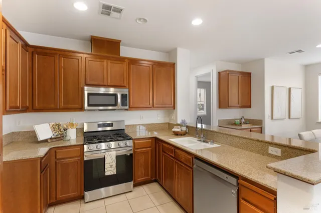 a kitchen with stainless steel appliances granite countertop a sink stove and microwave