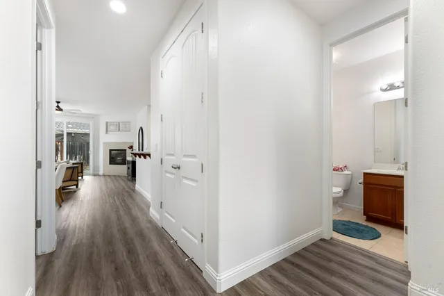 a view of a hallway view with wooden floor and living room