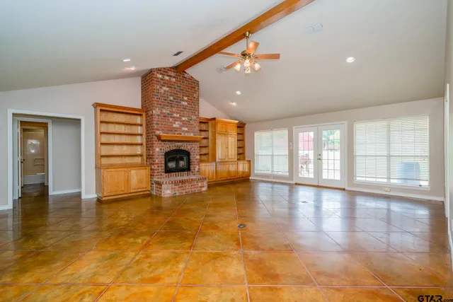 a view of empty room with fireplace and wooden floor