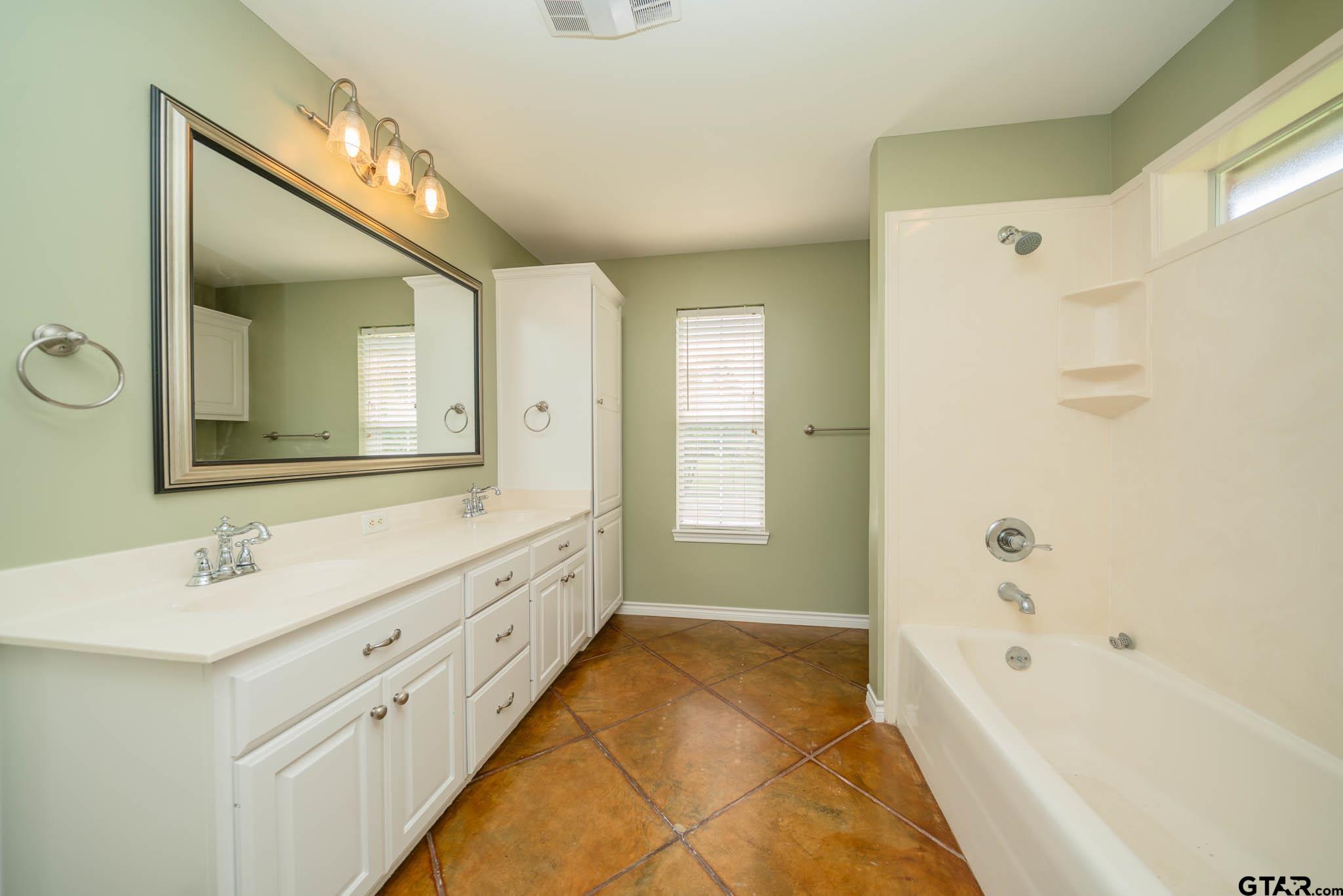 3460 Hawk Road Diana, TX 75640 - Photo 18 of 40 a spacious bathroom with a double vanity sink mirror and bathtub