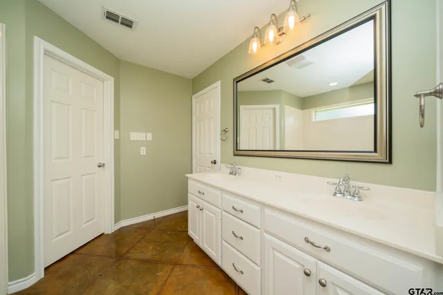 a bathroom with a double vanity sink and mirror