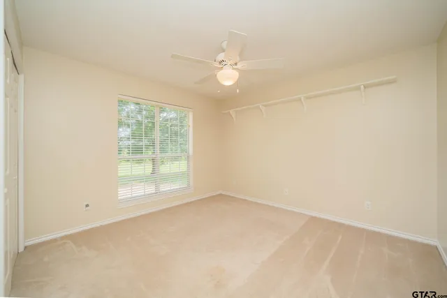 an empty room with a window and a fan