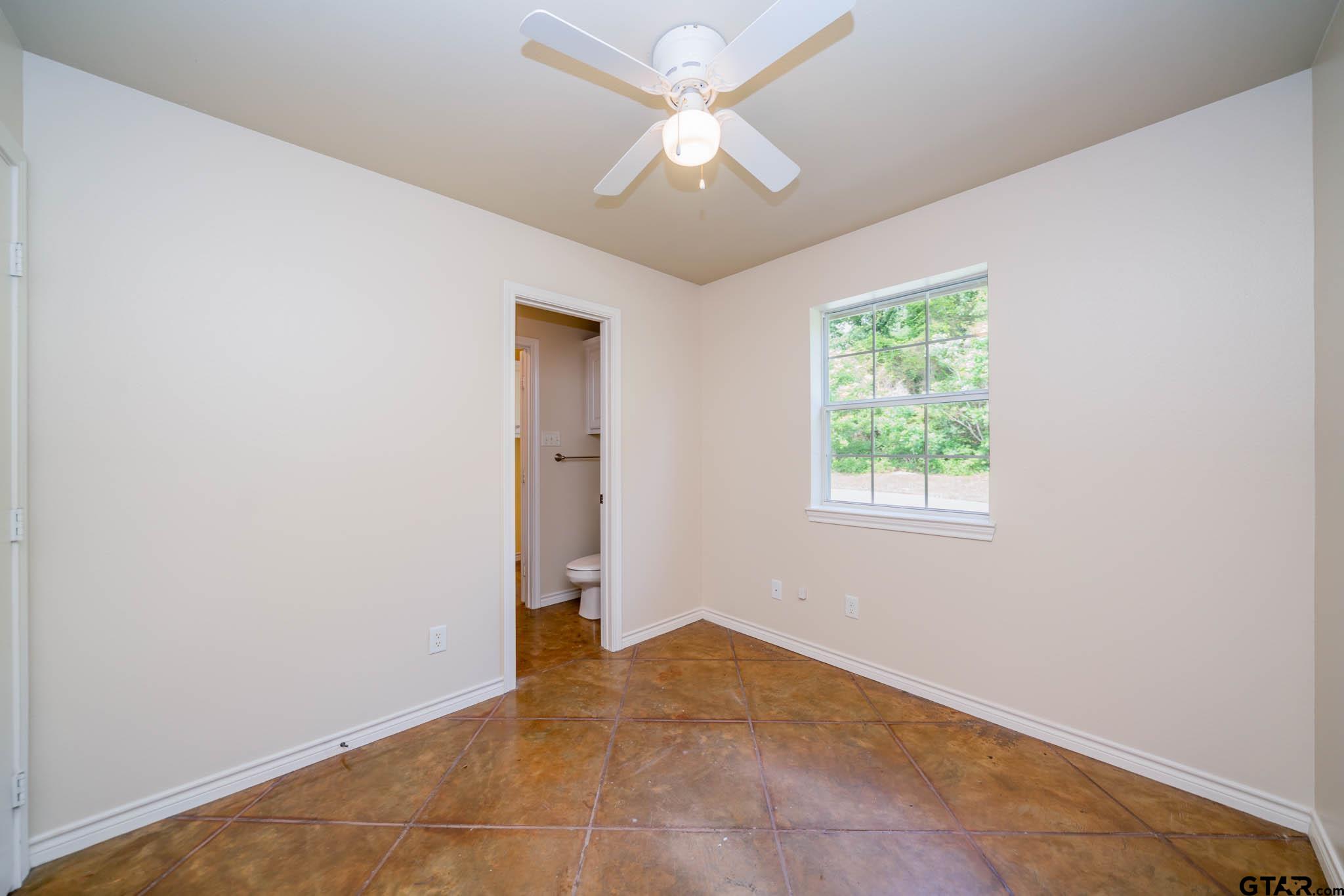 3460 Hawk Road Diana, TX 75640 - Photo 25 of 40 an empty room with a window and a fan